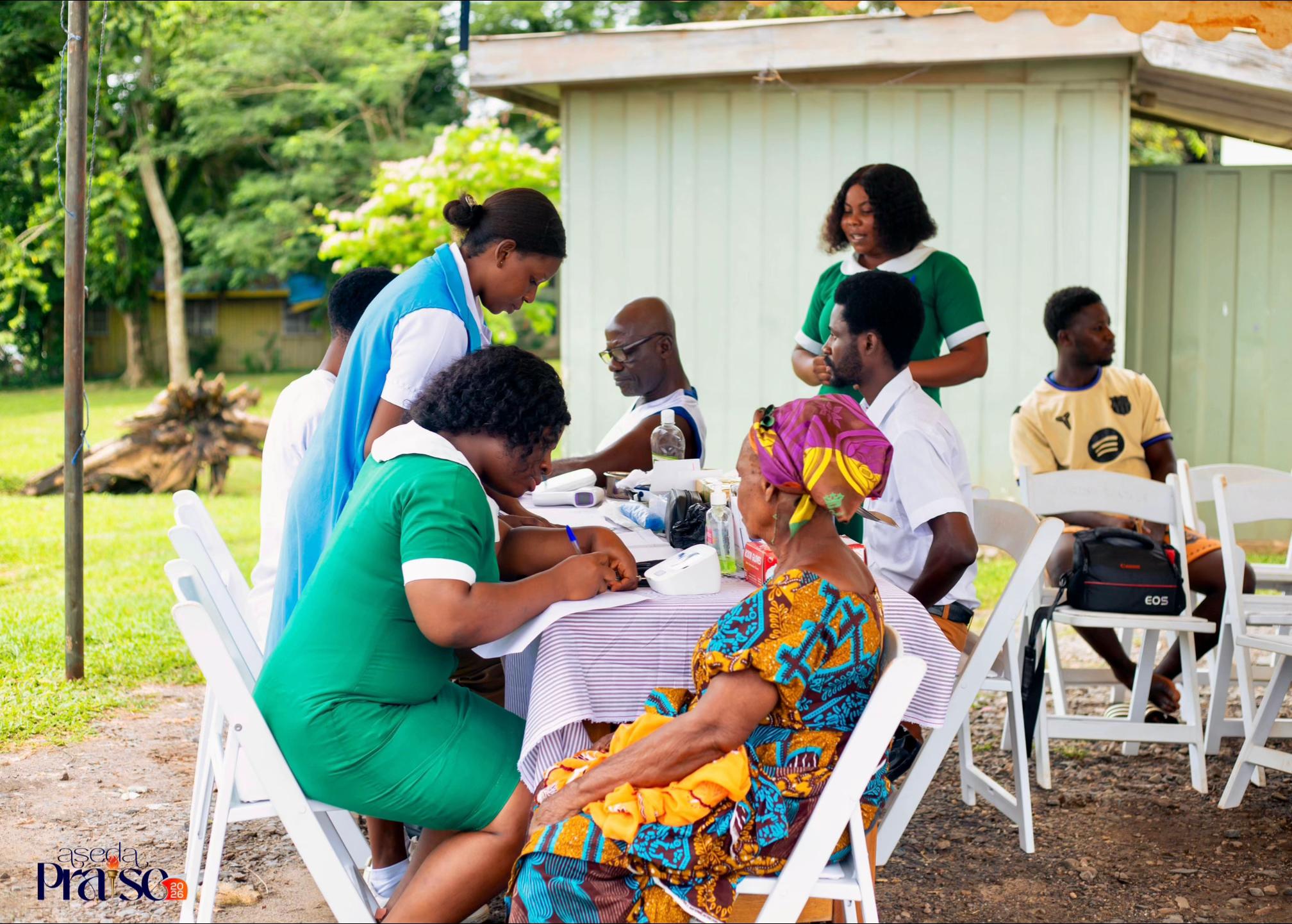 Nurses checking vitals and screening patient blood sugar during free rural health campaign